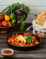 fried chicken pieces cooked with tomato, pepper, topped with fries