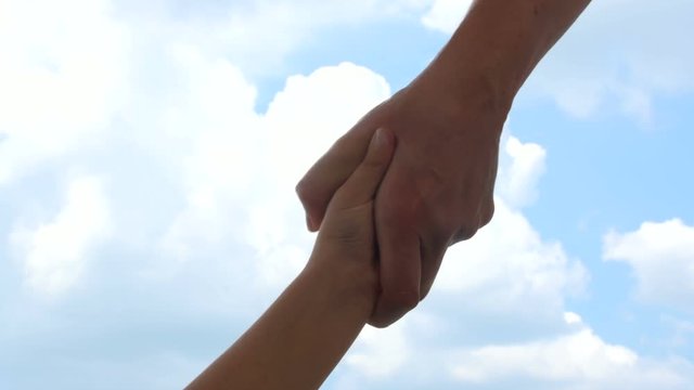 Mother's hand is strongly grabbing daughter's hand asking for help on a sky background FDV