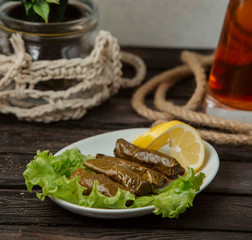 grape leaves dolma stuffed meat and rice, garnished with lemon slices