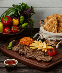 grilled beef steak pieces served with bulgur, grilled vegetables and fries