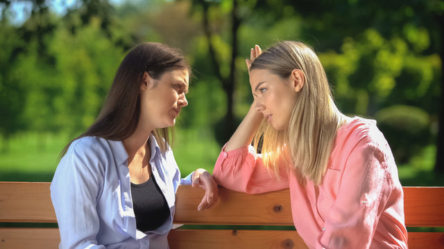 Young Female Supporting And Comforting Friend Sitting Park Bench, Depression