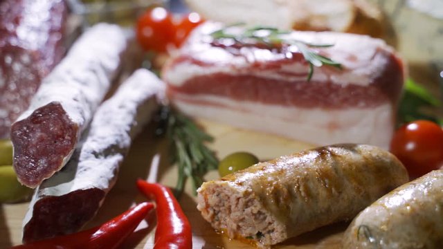 Assorted deli meats, ham, salami, bacon and tomatoes on the black stone tray