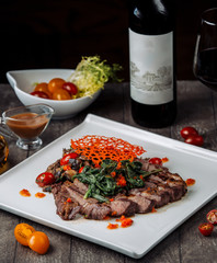 lamb kebab slices with aubergine salad garnished with spinach