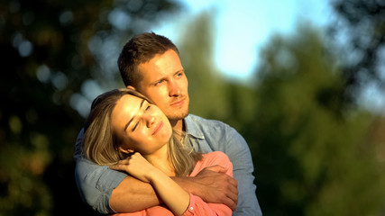 Hugging couple in park, tender relations, boyfriend and girlfriend romantic date