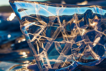 Sunset sky and ice on Lake Baikal. Winter ice on Lake Baikal. Crystal clear drinking water. The floe on Lake Baikal broke away and is reflected in the ice as in a mirror.