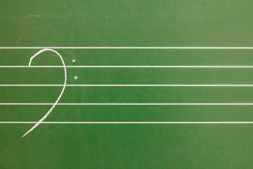 Musical blank staves on a blackboard with bass clef