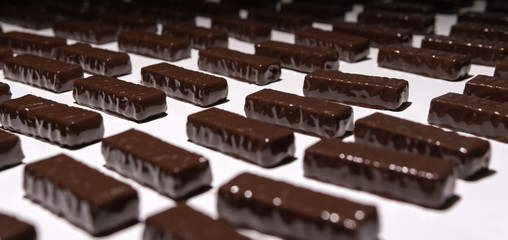 chocolate candies on the conveyor of a confectionery factory close-up