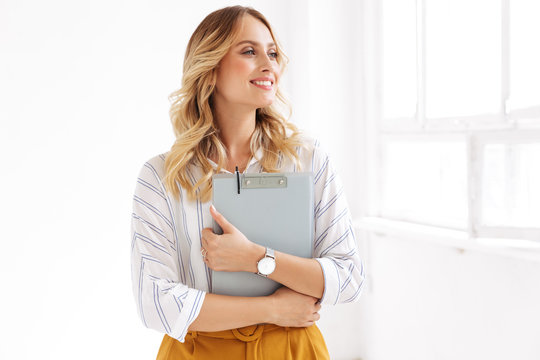 Image of attractive elegant secretary woman holding clipboard in office