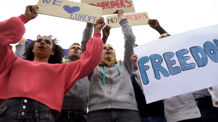 Activists chanting slogan holding posters for no borders in EU, migration crisis