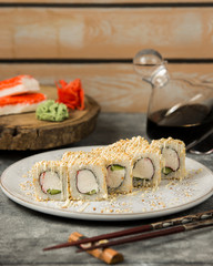 sushi rolls with crab sticks and cucumber covered in sesame