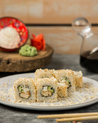 tempura sushi rolls covered with sesame and sauce