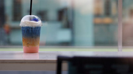 Colorful ice milky drink by the coffee shop window. Selected focus. Wide aspect ratio 16:9.