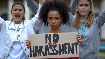 Crowd holding banners on anti-harassment rally against silence of violence abuse