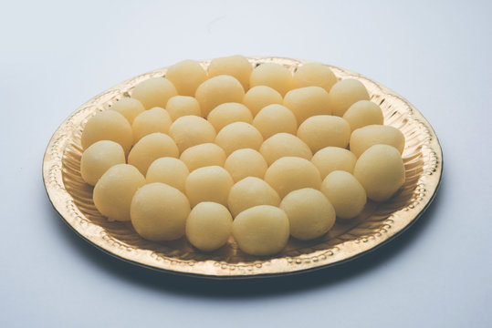 Indian Rasgulla or dry Rosogulla dessert/sweet served in a golden plate. selective focus