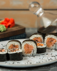 close up of salmon maki rolls garnished with sesame