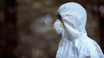 Biochemist wearing protective uniform in abandoned forest, statistic template