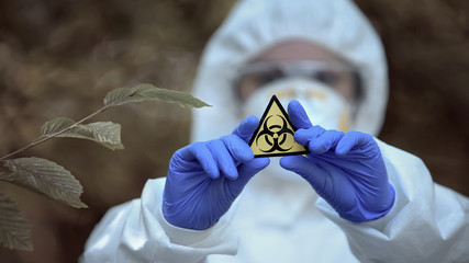 Biological hazard sign in researcher hands, health threat, virus danger, toxin