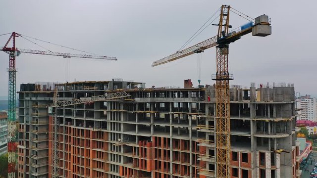construction of a residential apartment complex. Multi-storey building under construction. Building cranes are working. Aerial view.