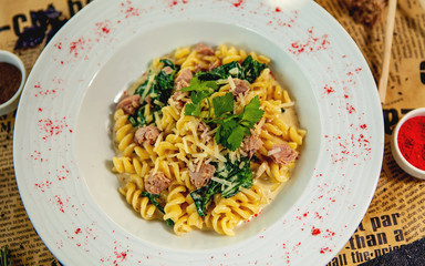 creamy fusulli with tuna and spinach garnished with parmesan