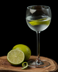 glass of lime water with lime zest on wood serving board