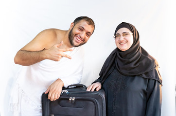 Muslim mother and her son wearing pilgrimage clothes and ready with their bag to go to mecca