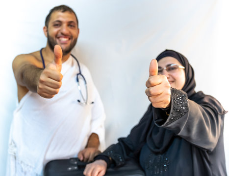 Muslim woman and her son wearing pilgrimage clothes and their thumbs up