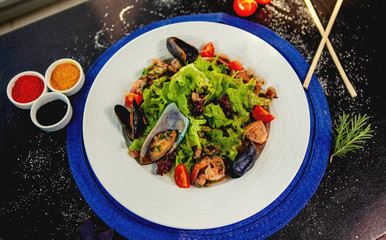 top view of seafood salad with fresh lettuce, tomato, fried shrimp and mussels