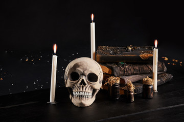 Realistic model of a human skull with teeth on a wooden dark table, black background. Medical...