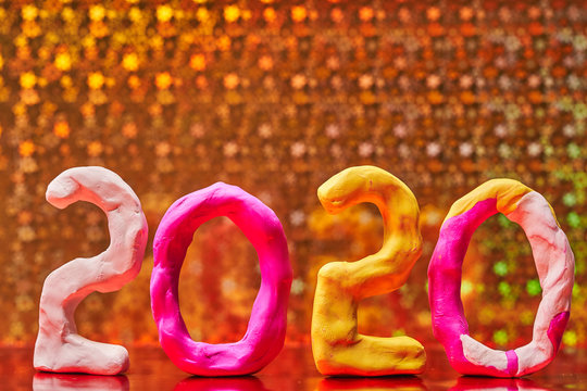2020 New year design concept. Colored figures of plasticine on a Golden background