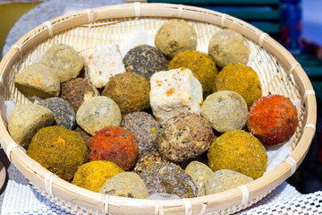 Large selection of cheese varieties on a wooden table background.