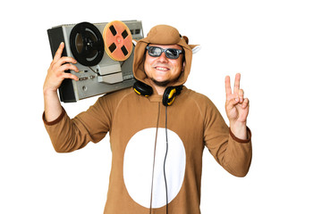 Man in cosplay costume of a cow with reel tape recorder isolated on white background. Guy in the...