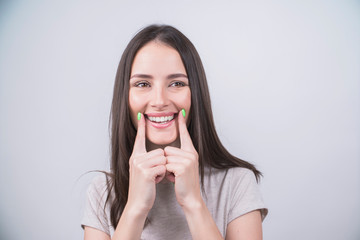 girl pointing healthy smile over grey background