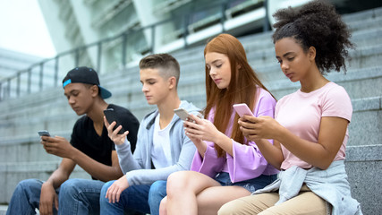 Obraz premium University students chatting smartphones online, lack communication, addiction
