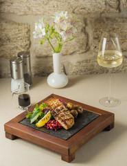 grilled lamb with potatoes, garnished with pomegranate, lemon, and fresh herb salad