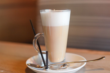 Glass cup of coffee latte on wooden table