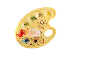 Artist palette with palette knife, mixed paints on white background.