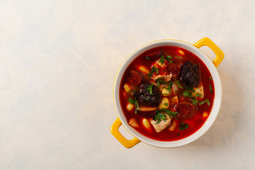 Traditional Spanish goulash soup. Fabada Asturiana. Served with a yellow clay pot with lid. Top view.
