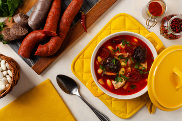 Traditional Spanish goulash soup. Fabada Asturiana. Served with a yellow clay pot with lid. Top...