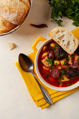Traditional Spanish goulash soup. Fabada Asturiana. Served with a yellow clay pot with lid. Top...