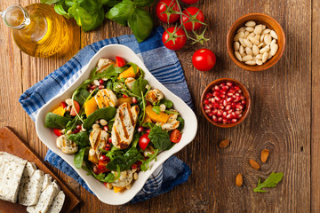 Traditional Greek salad with grilled Halloumi cheese with basil. Top view. Flat lay.