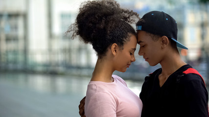 Black couple of teenagers hugging during outdoor date, love connection affection - obrazy, fototapety, plakaty
