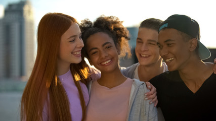 Multi-ethnic high best friends smiling camera and hugging, trustful relations