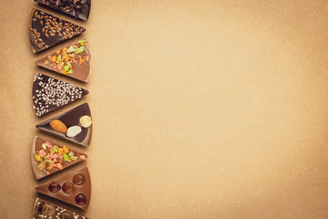 Pieces of chocolate on craft paper. Sweet dessert. Spiced chocolates on vintage parchment, brown...