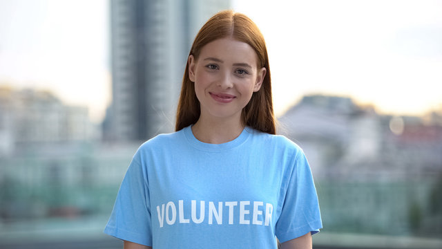 Red-haired female teenager smiling camera, college volunteer project, kindness