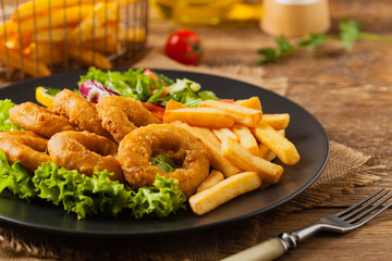 Roasted squid rings with fries.