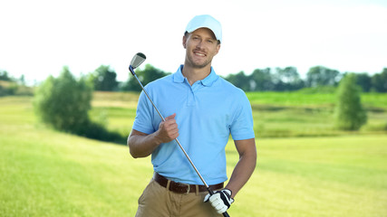 Happy golf player with club smiling on camera, luxury hobby and sport, activity