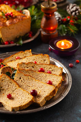 Delicious chicken and pork pate in Christmas decoration. Rustic style. Dark background, metal plates. Front view.