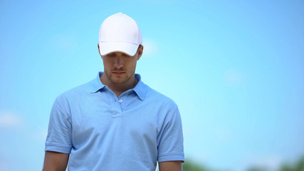 Upset sportsman looking down, displeased with losing, depression and stress