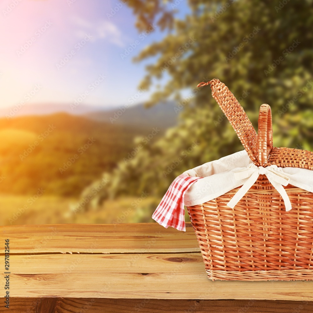 Wall mural Picnic Basket with napkin om nature background