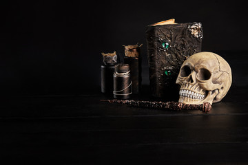 Realistic model of a human skull with teeth on a wooden dark table, black background. Medical...